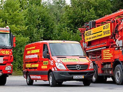 Rote Einsatzfahrzeuge und ein LKW auf einer Straße, davor ein Mercedes-Transporter, im Hintergrund ein grüner Wald.