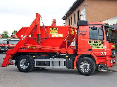 Ein roter Abschleppwagen parkte neben einem Gebäude an einer Straße
