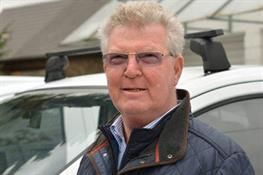 Ein Mann mit Brille steht vor einem weißen Auto. Karl-Heinz Müller GmbH