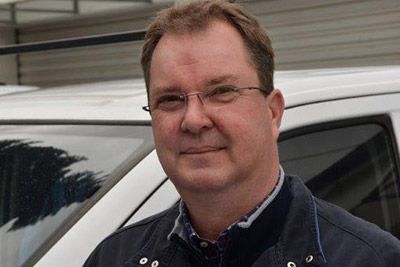 Ein Mann mit Brille steht vor einem weißen Lieferwagen. Karl-Heinz Müller GmbH