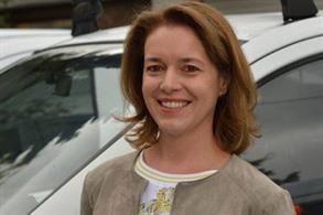 Eine Frau lächelt vor einem weißen Auto. Karl-Heinz Müller GmbH