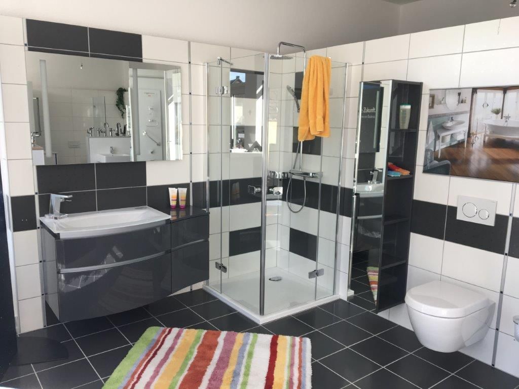 Ein Badezimmer mit Dusche, Waschbecken, Toilette und Spiegel