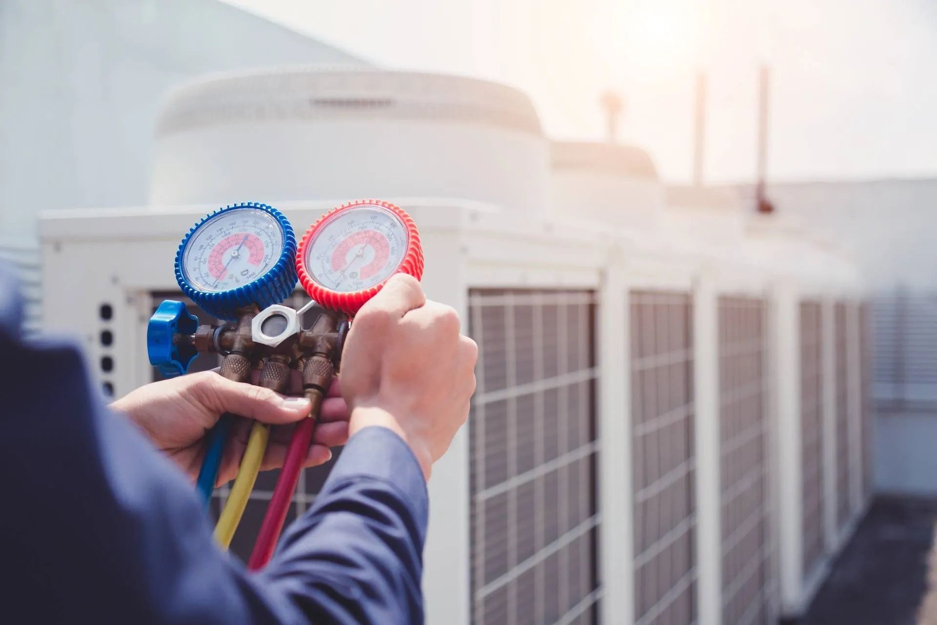 Ein Mann arbeitet außerhalb eines Gebäudes an einer Klimaanlage.