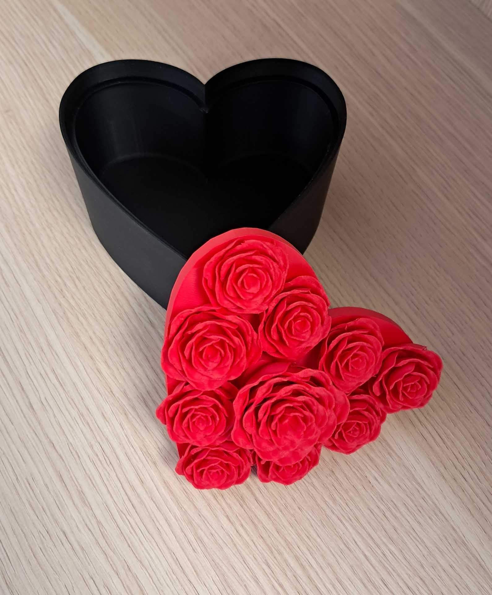Boîte noire en forme de cœur avec des roses rouges sur une surface en bois clair