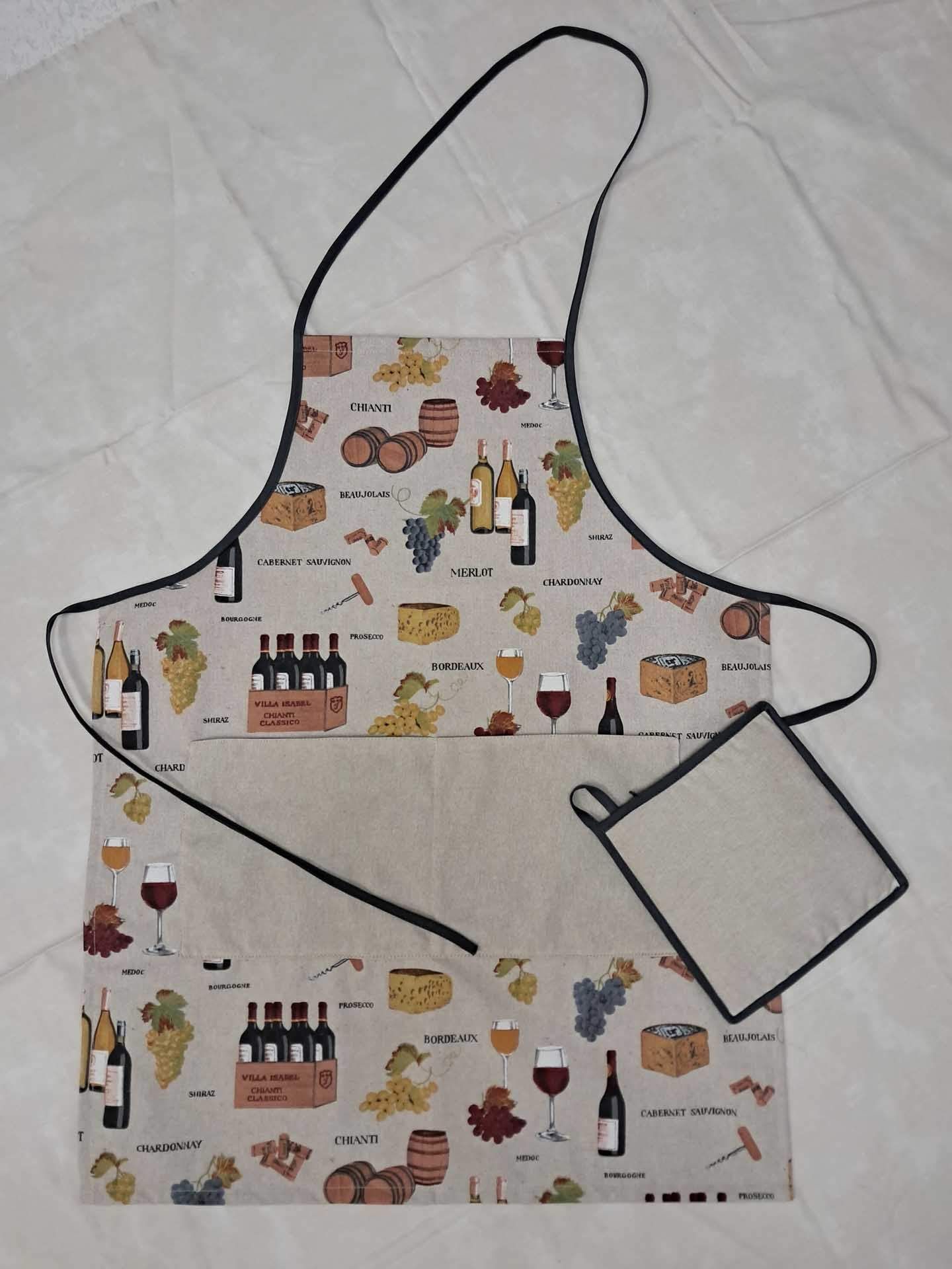 Tablier à motifs avec une lanière autour du cou et une manique assortie sur un fond en tissu clair