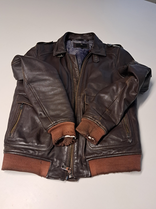 Veste en cuir marron à poignets et ourlet côtelés, posée à plat sur fond blanc