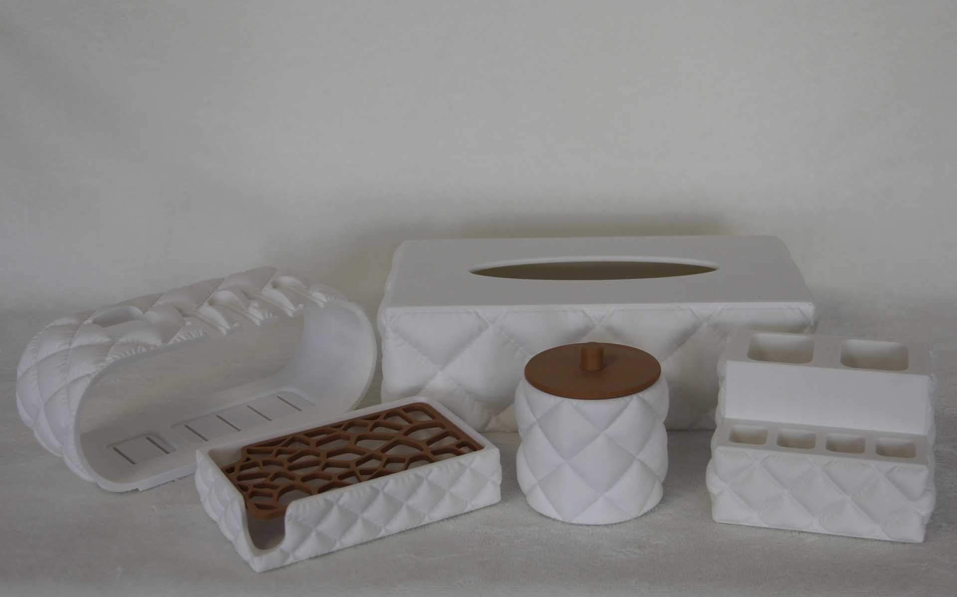 Boîtes décoratives blanches matelassées et un plateau contenant des objets beiges sur une surface gris clair.