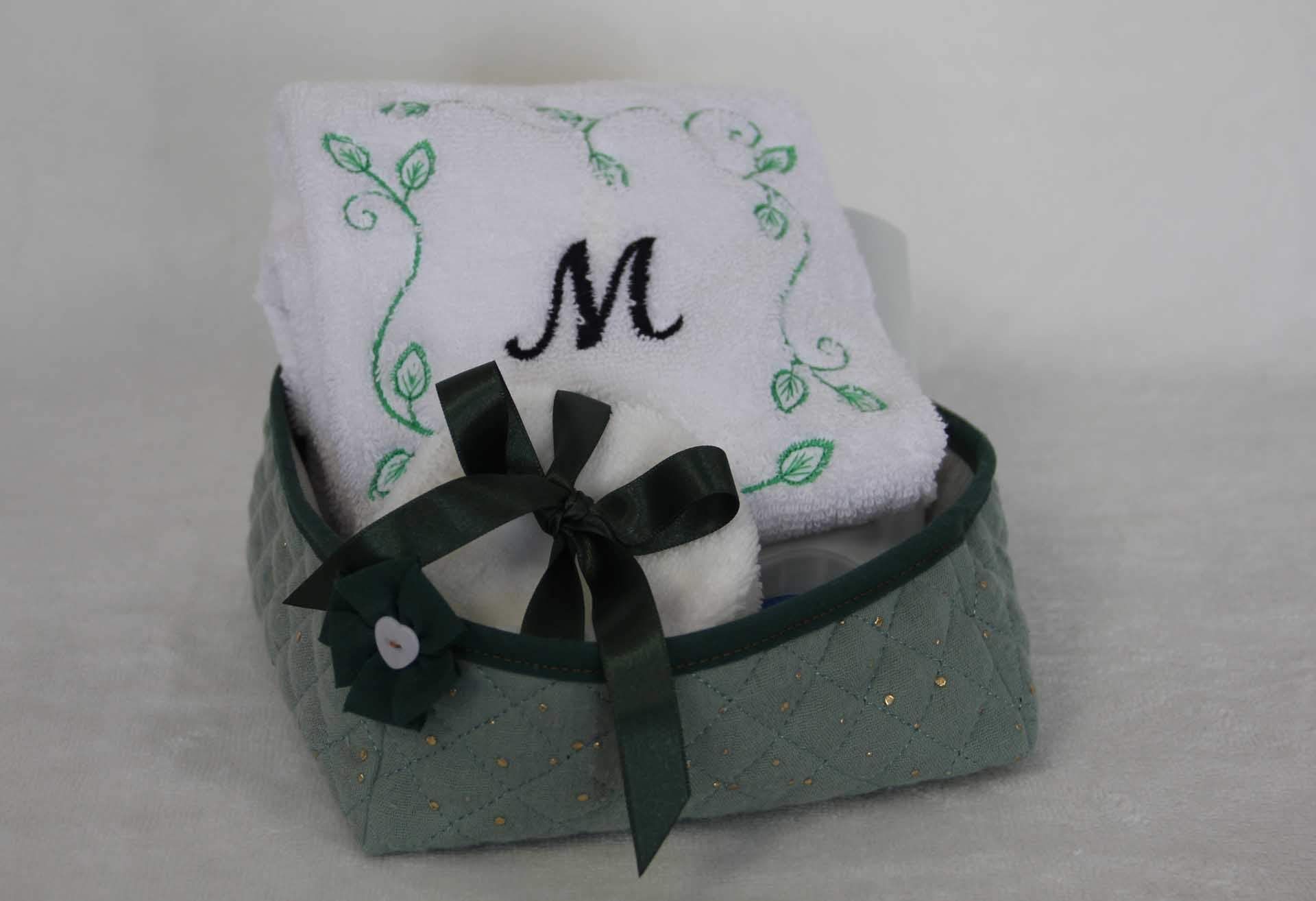 Coussin blanc brodé à motif de vigne verte et ruban noir dans un panier vert