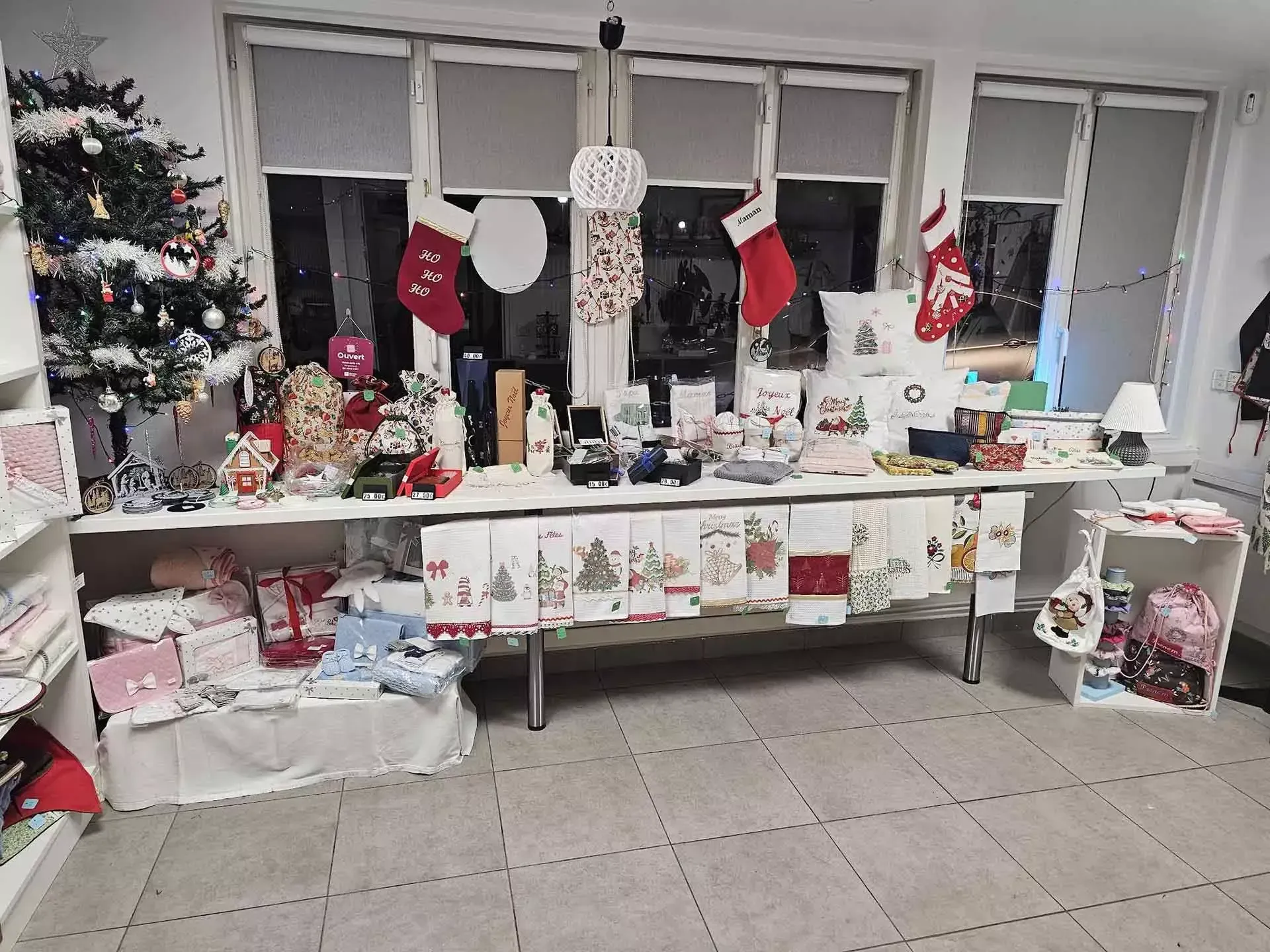 Présentation de cadeaux de Noël sur des tables avec des chaussettes, des cartes et des décorations de Noël dans une pièce