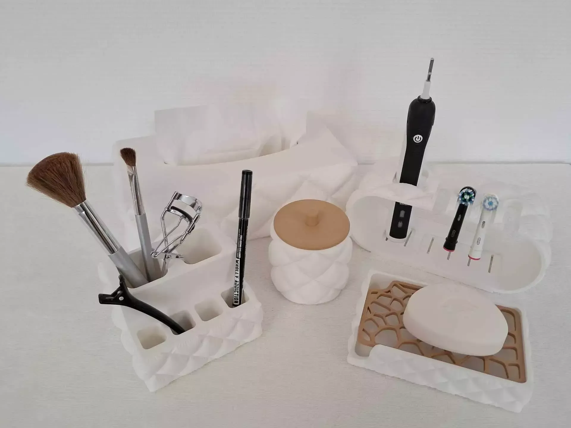 Accessoires de salle de bain et articles de toilette variés disposés sur une surface blanche, notamment brosses, savon, cotons-tiges et flacons.