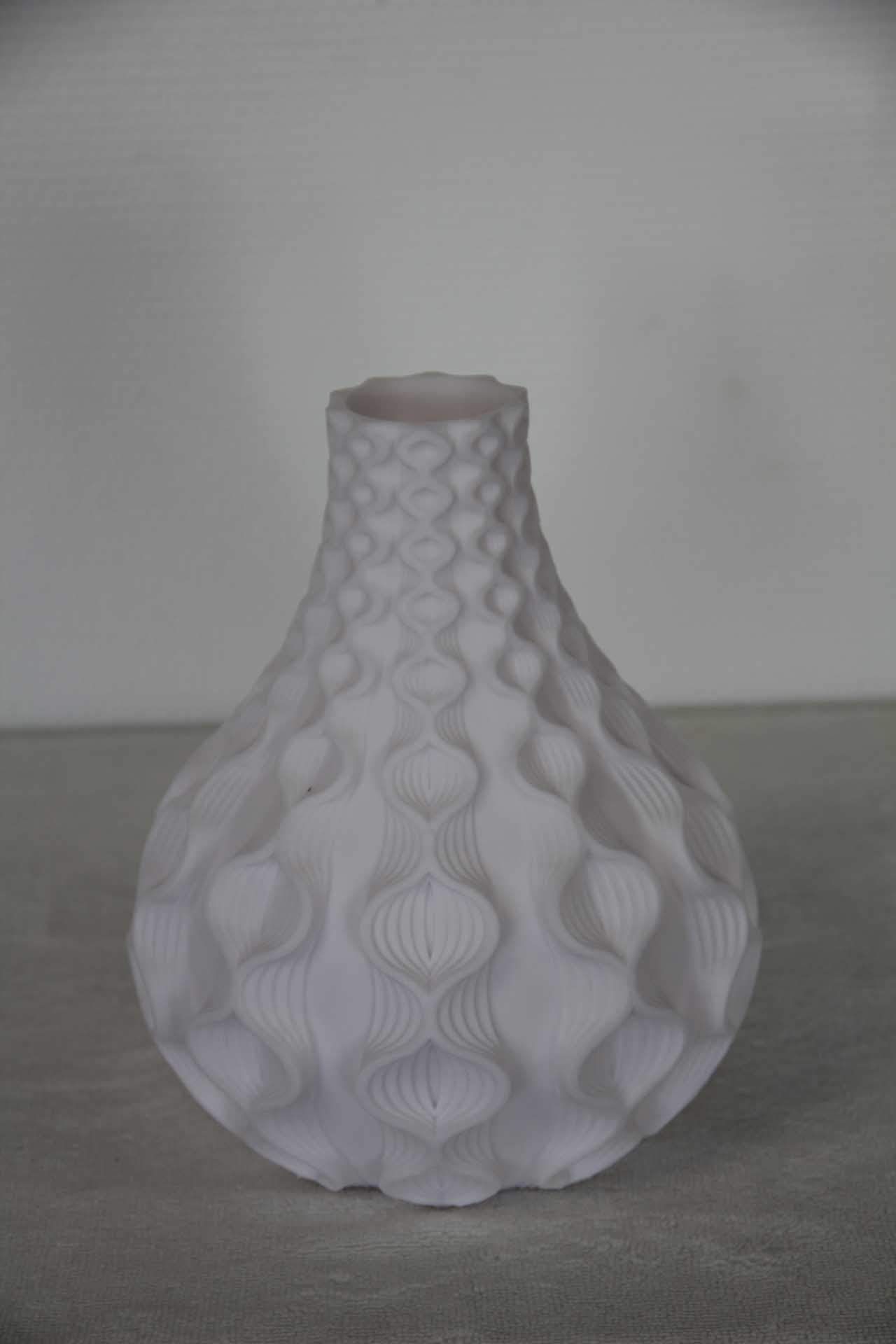 Vase en céramique blanche texturée à corps bulbeux sur fond gris uni
