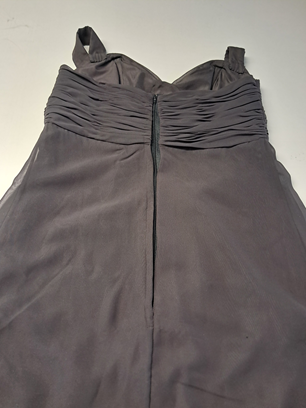 Robe noire sans manches à corsage froncé, posée à plat sur une surface claire.