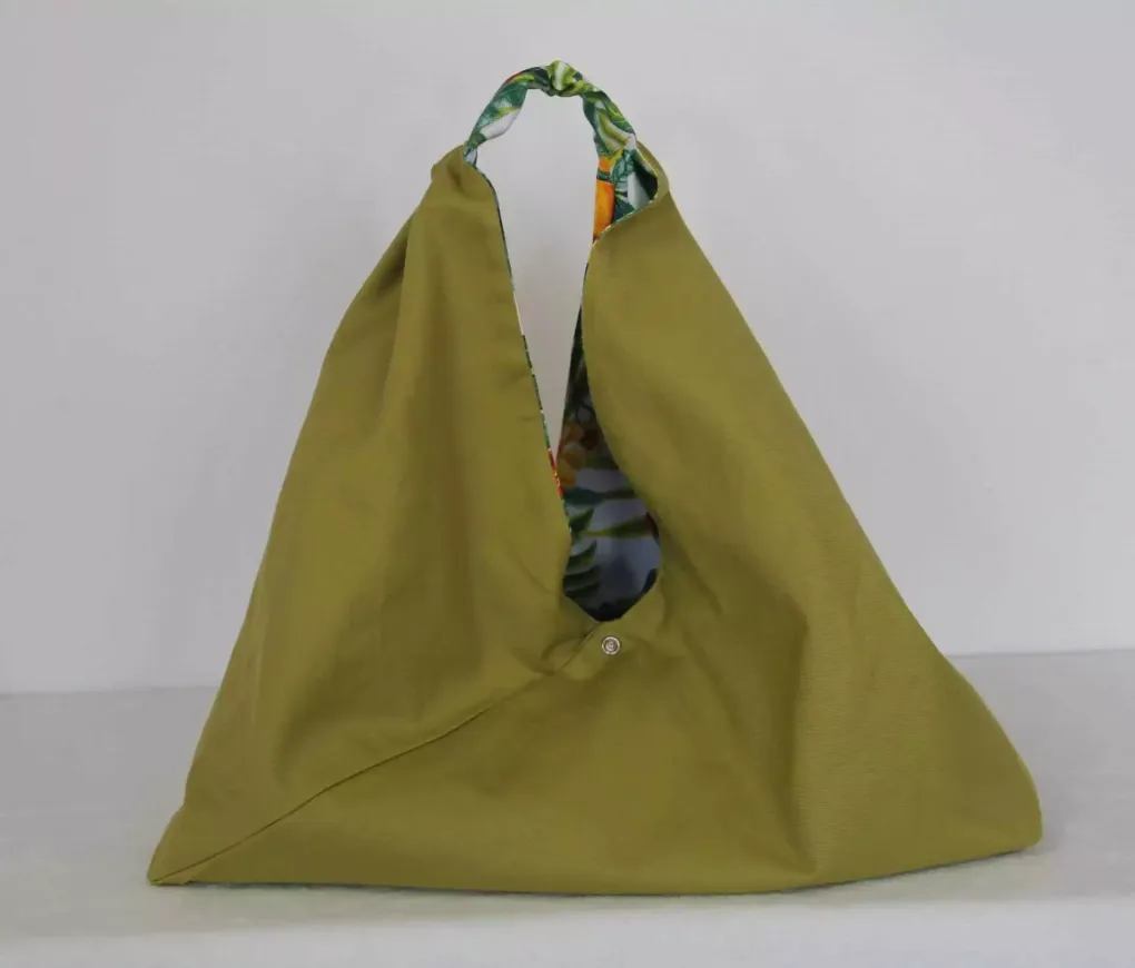 Sac cabas vert olive à anses à motifs, présenté sur un fond clair uni
