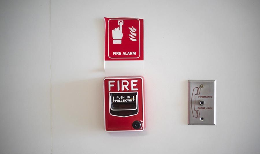 Una alarma de incendio roja en una pared blanca