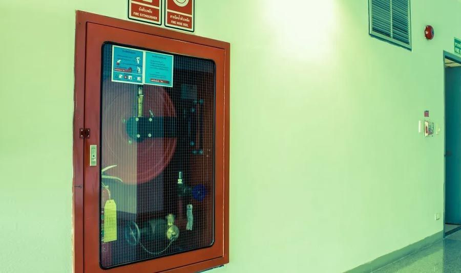 Un extintor de incendios está colgado en una pared en un pasillo.