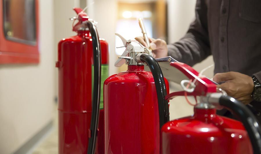 Un hombre sostiene un extintor de incendios en un pasillo.