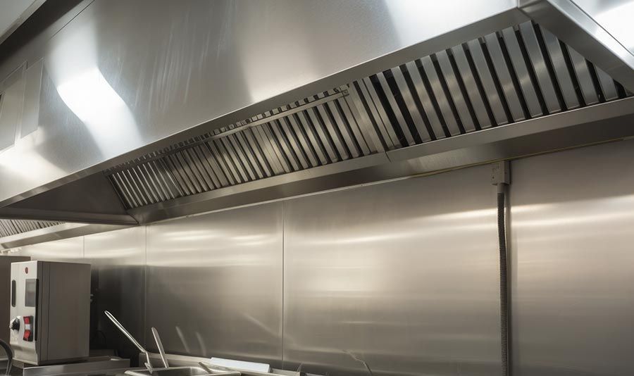 Una cocina con electrodomésticos de acero inoxidable y campana extractora.