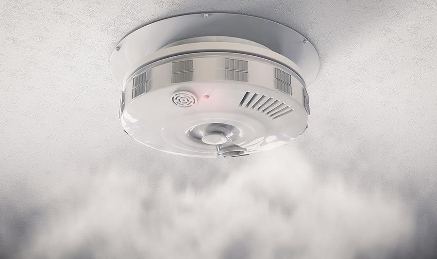 Un detector de humo en el techo del que sale humo.