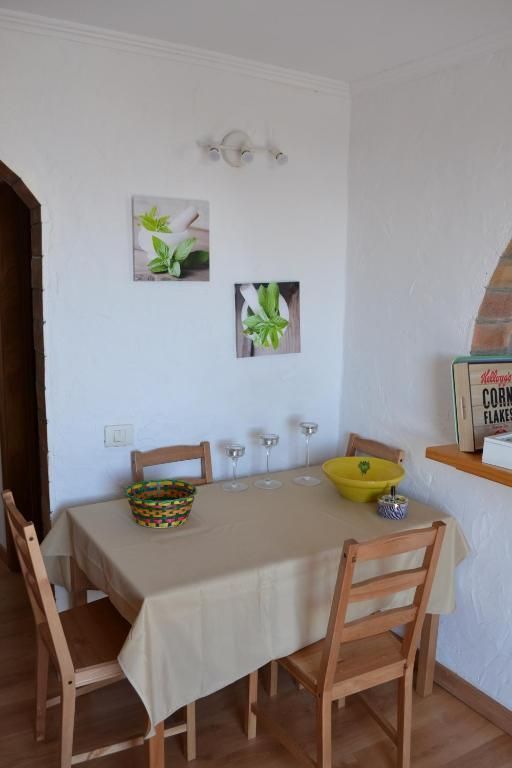 Una cocina con una mesa y sillas y una caja de copos de maíz Kellogg's.