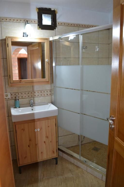 Un baño con lavabo, espejo y ducha.