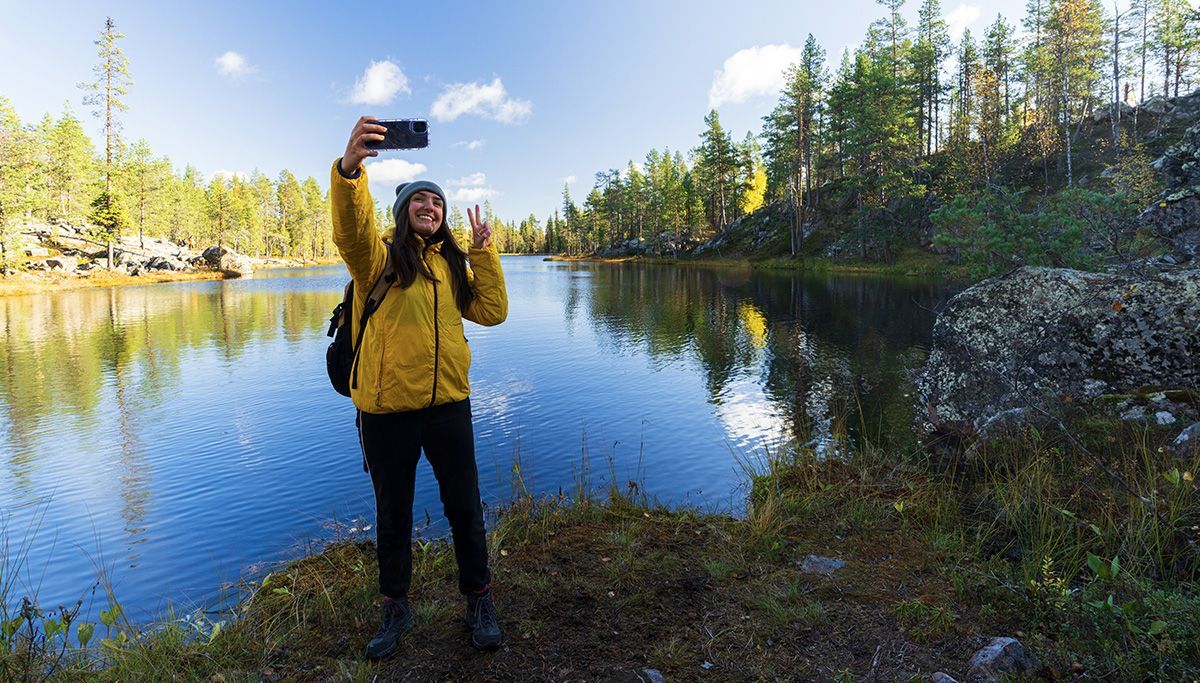 Woman using smartphone in finnish nature.