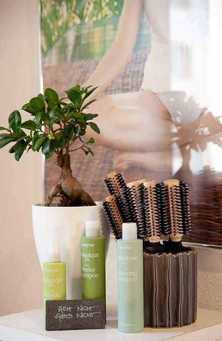 Spa-Produkte und Haarbürsten lagen auf einem Tisch neben einer kleinen Topfpflanze und Wandbildern.