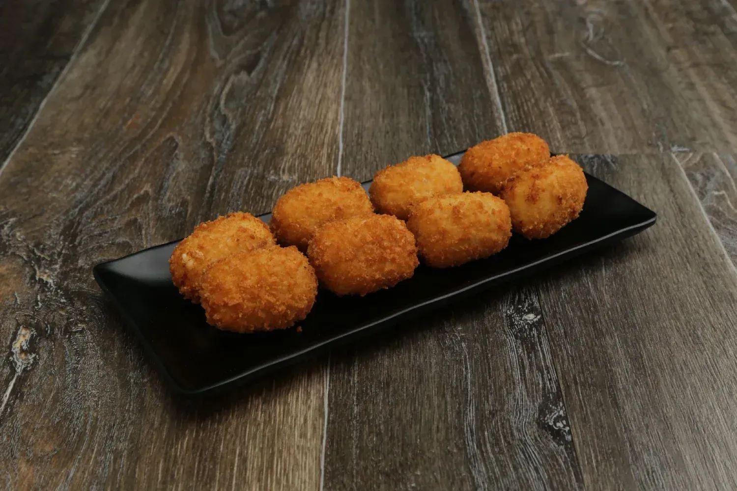 Dos platos de comida y una bebida sobre una mesa de madera.