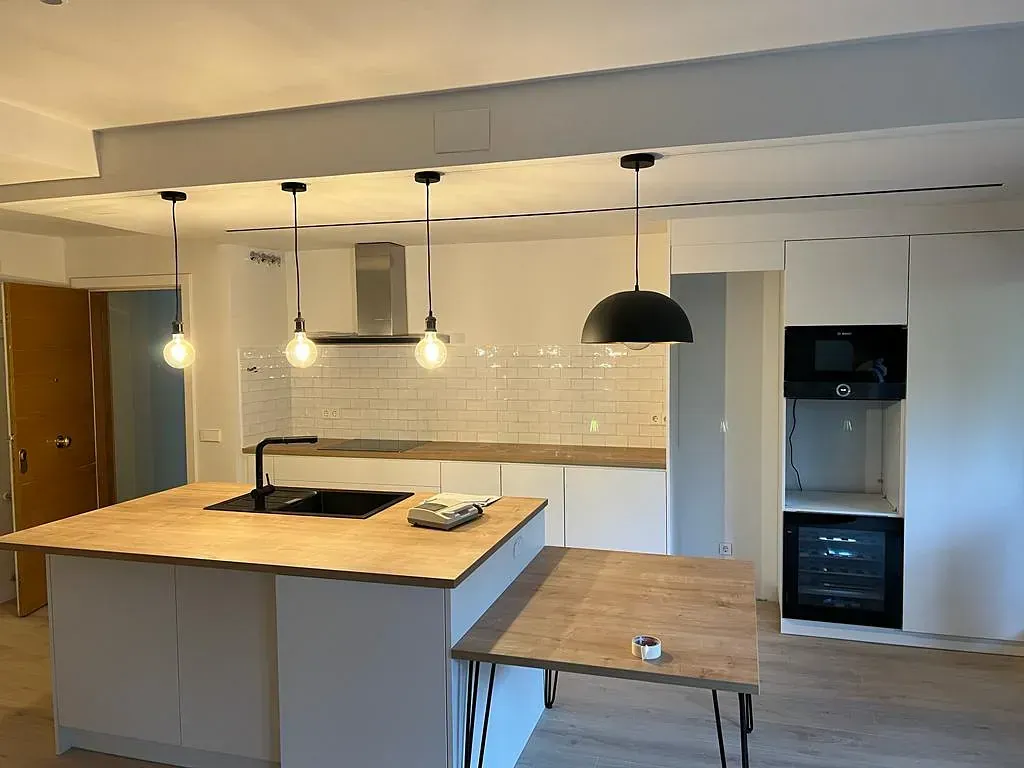 Una cocina con una gran isla y una mesa.