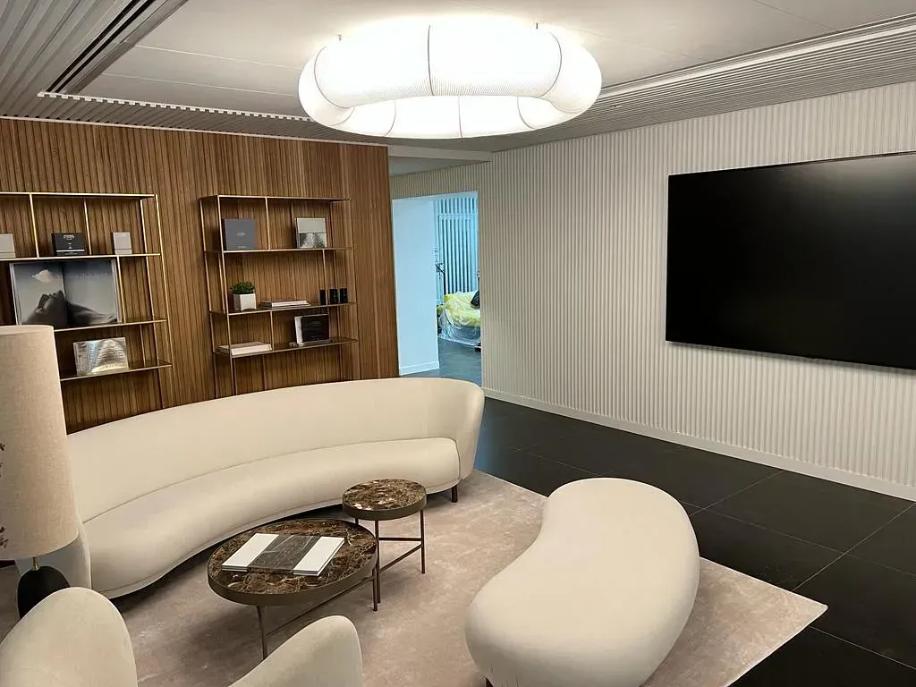 Una sala de estar con un sofá curvo y un televisor de pantalla plana.