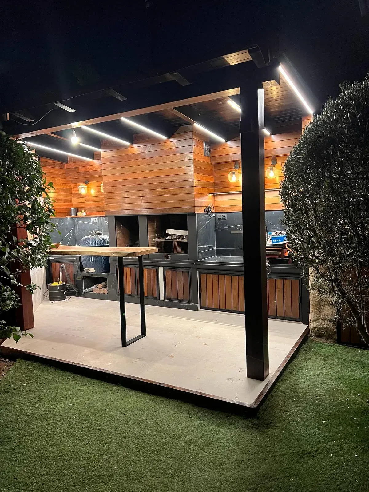 Una gran cocina al aire libre está iluminada por la noche.