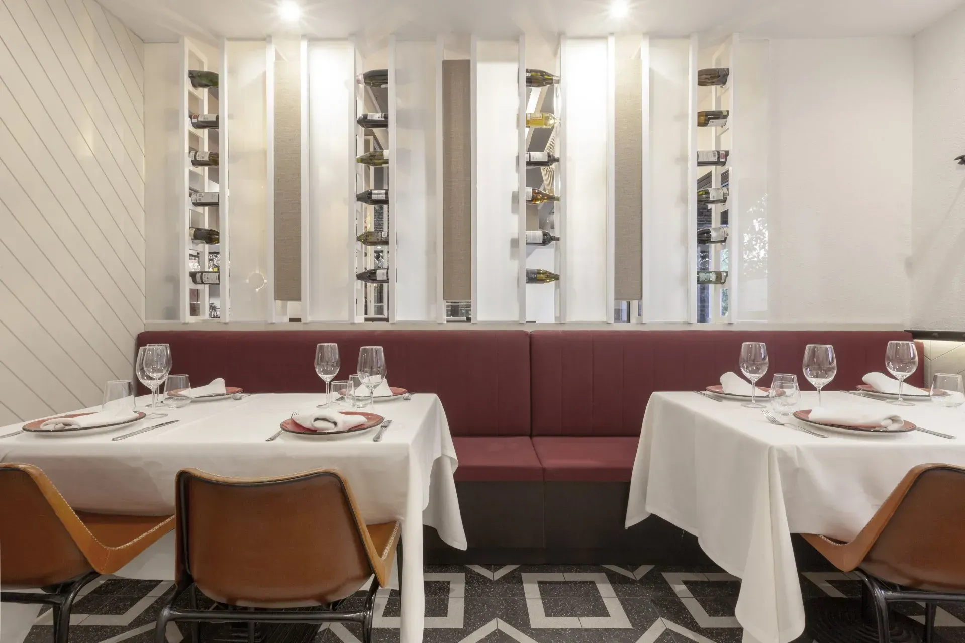 Un comedor con mesas y sillas preparadas para comer.