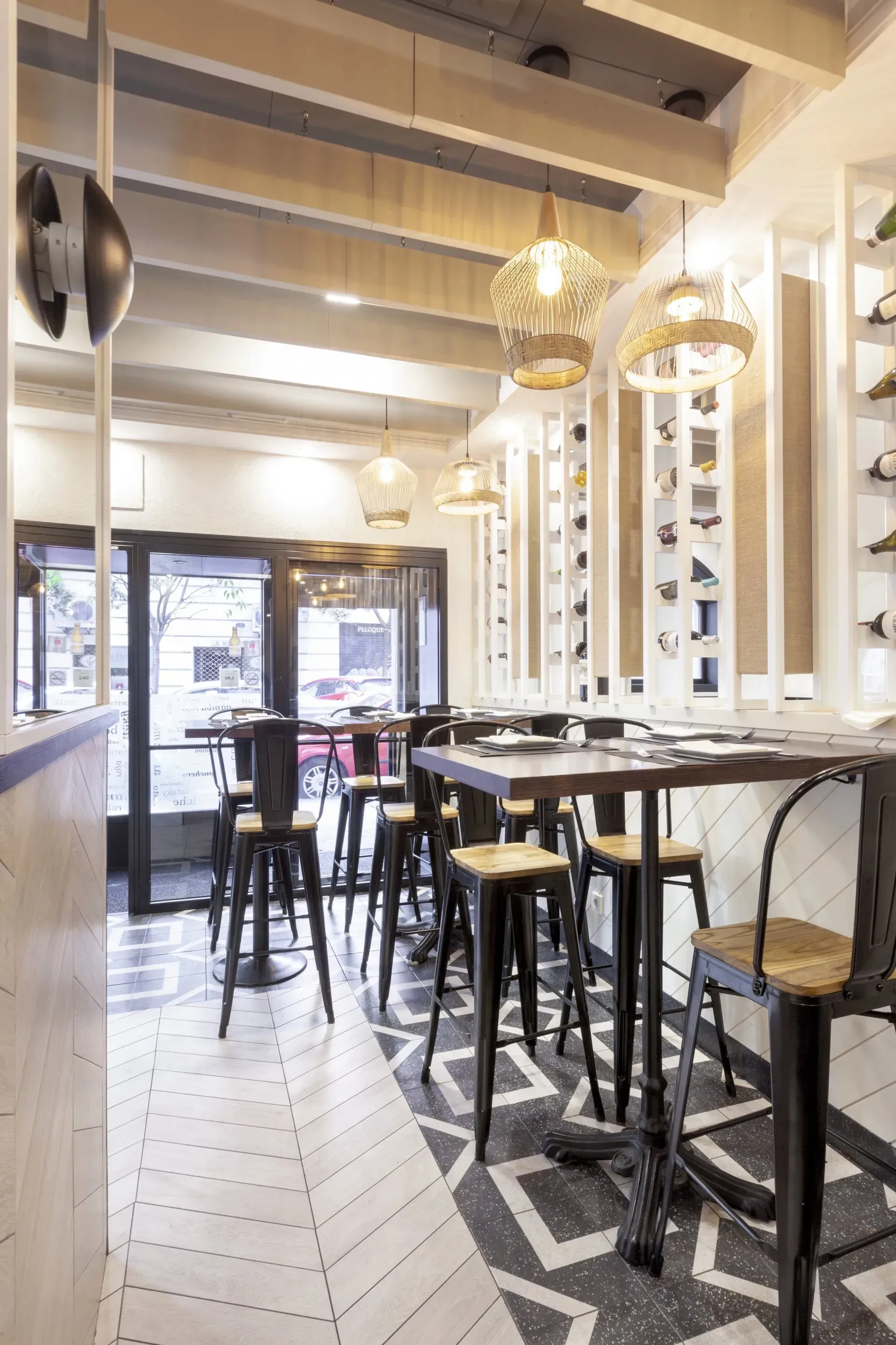 Un restaurante con mesas y sillas y un botellero en la pared.