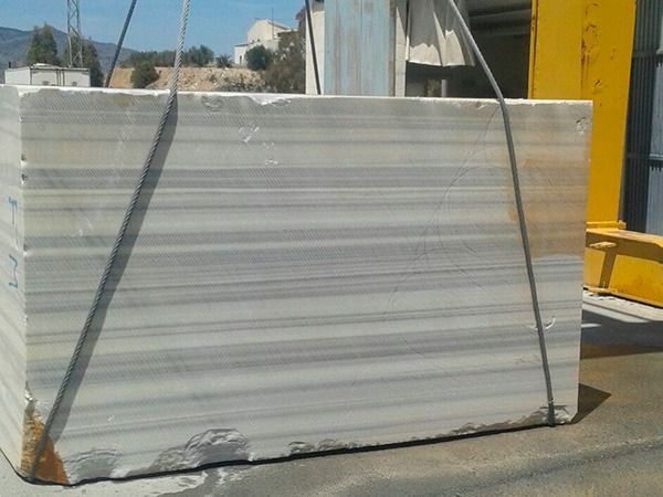 Se levanta un gran bloque de mármol mediante una grúa.