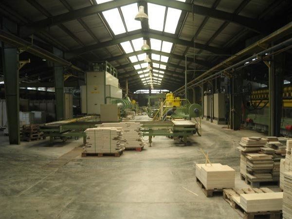 Un gran almacén lleno de muchos ladrillos y maquinaria.