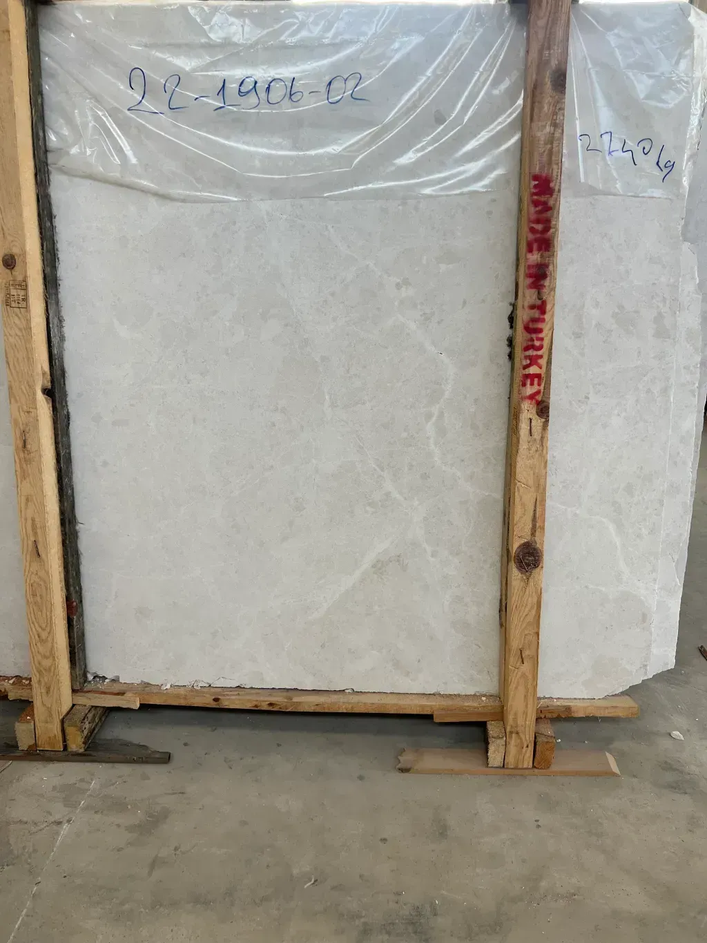 Una losa de mármol blanco se encuentra en una caja de madera.