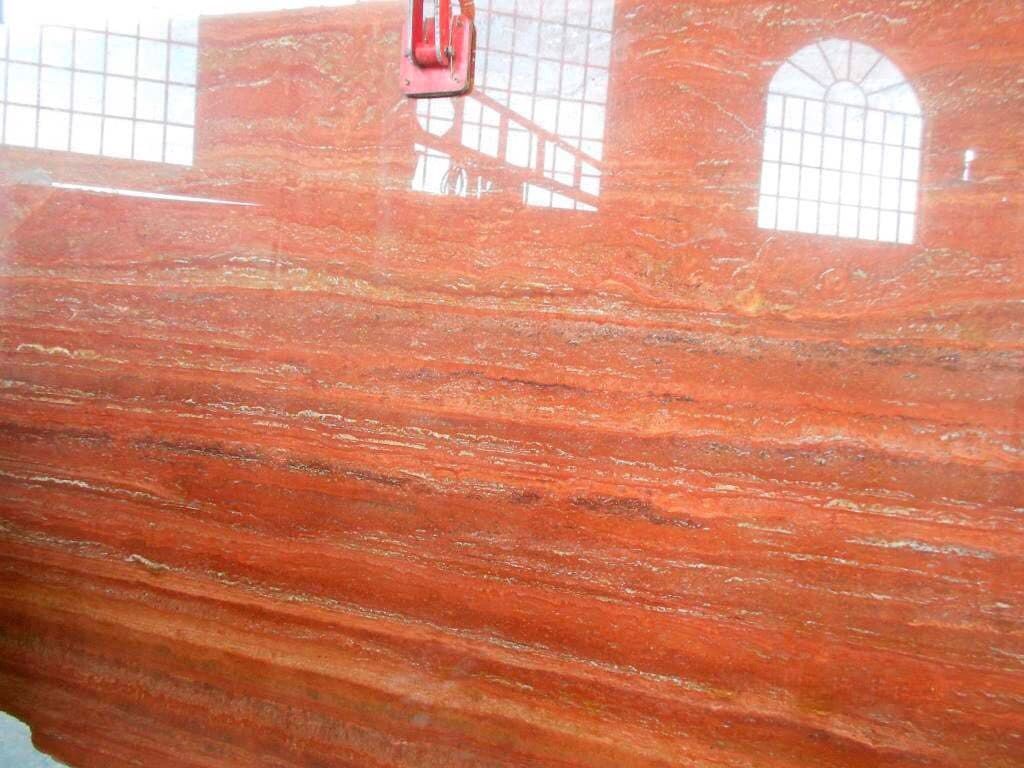 Una encimera de granito rojo con una ventana al fondo.