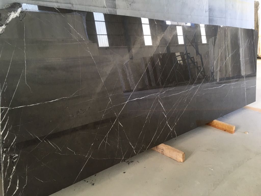 Una gran losa de mármol negro reposa en el suelo de una habitación.