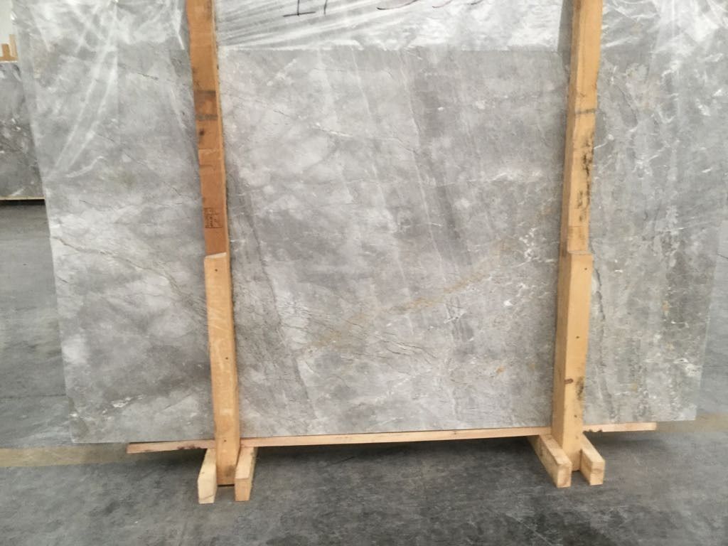 Una baldosa gris está colocada sobre un soporte de madera.