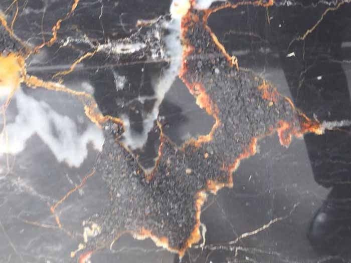 Un primer plano de una encimera de mármol negro y dorado.