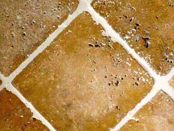 Un primer plano de un piso de baldosas con un borde blanco.