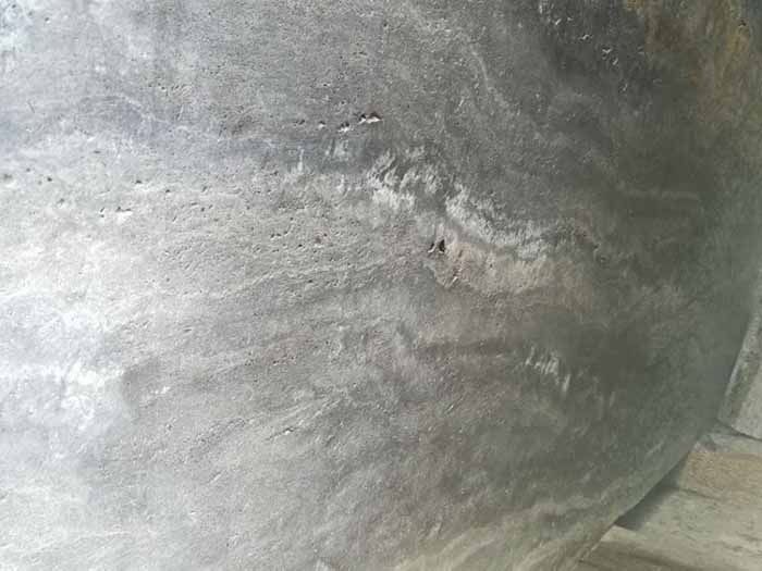 Un primer plano de una superficie de hormigón gris con un agujero en ella.