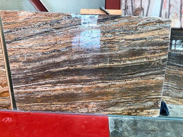 Un trozo de mármol reposa sobre una mesa roja.