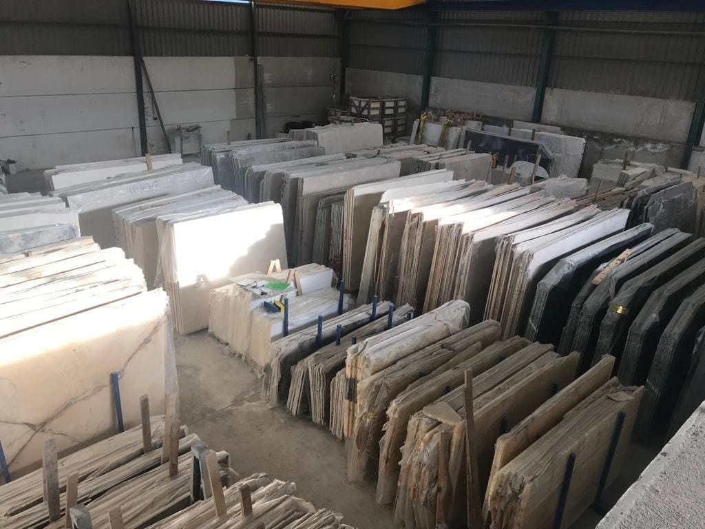 Un gran almacén lleno de muchas losas de mármol.