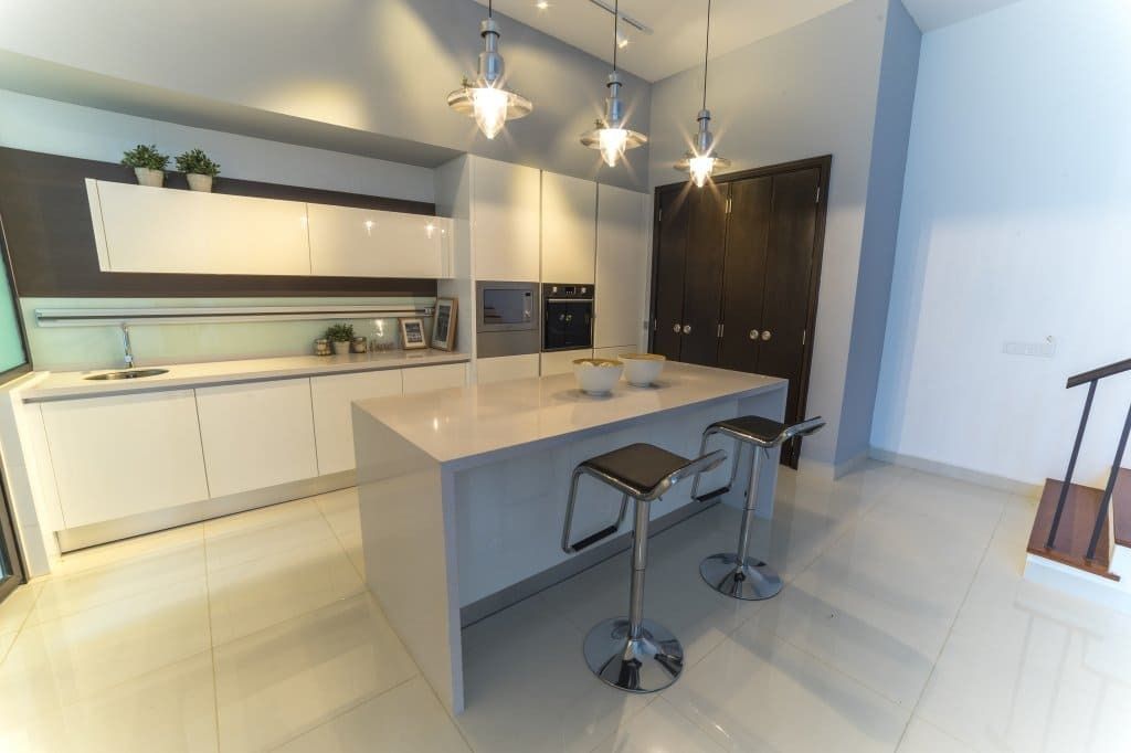 Una cocina con una gran isla y taburetes.