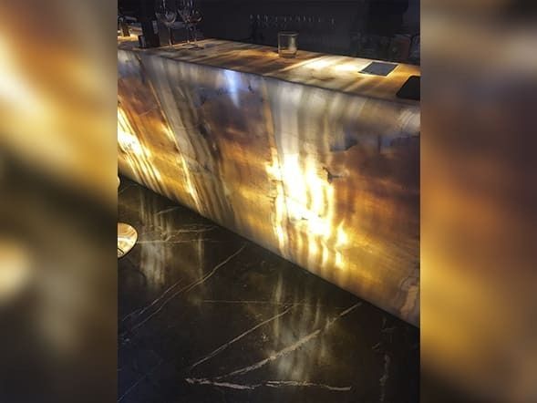 Una barra con encimera de mármol y una luz encima.