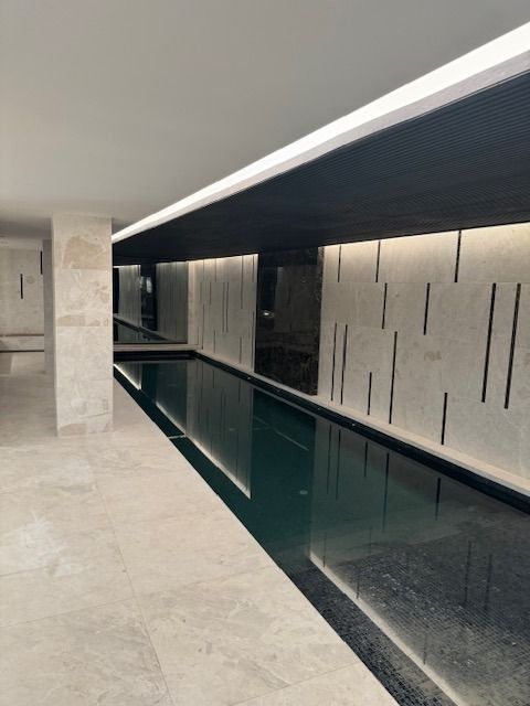 Una gran piscina cubierta con suelo de baldosas blancas.