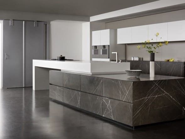 Una cocina con una gran isla y gabinetes blancos.