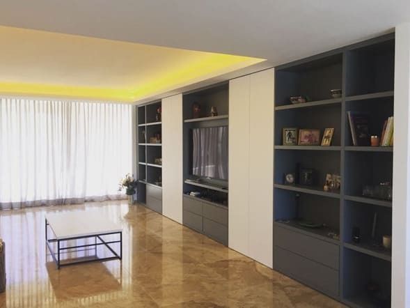 Una sala de estar con muchos estantes y un televisor.