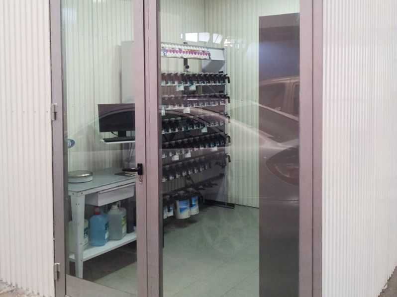 Una habitación con una puerta de cristal y una computadora sobre una mesa.