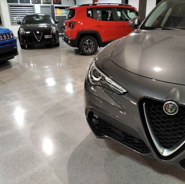 Una fila de coches están aparcados en un garaje, incluido un Alfa Romeo Stelvio.